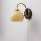 Beige dome glass sconce with pull-chain switch and brass collar