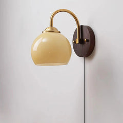 Beige dome glass sconce with pull-chain switch and brass collar