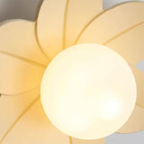 Detail of the beige petals and the lit glass globe seen from directly below