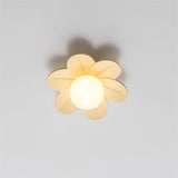 Beige petal ceiling light lit against a plain wall with a warm glass globe