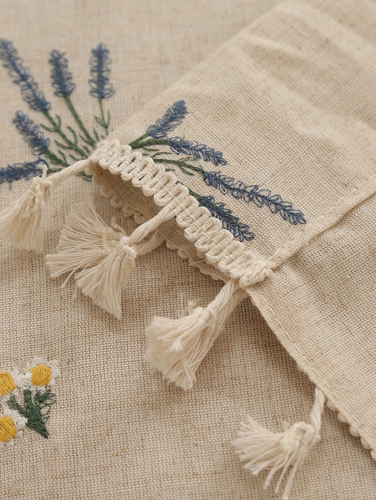 Sheer beige linen curtain with embroidered detailing and fringe texture