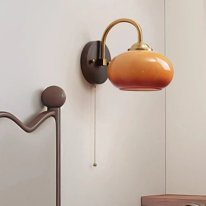 Beige oval glass sconce with brass arm on ash wood plate, plug-in