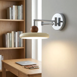 Beige disc shade wall sconce with chrome swing arm close up
