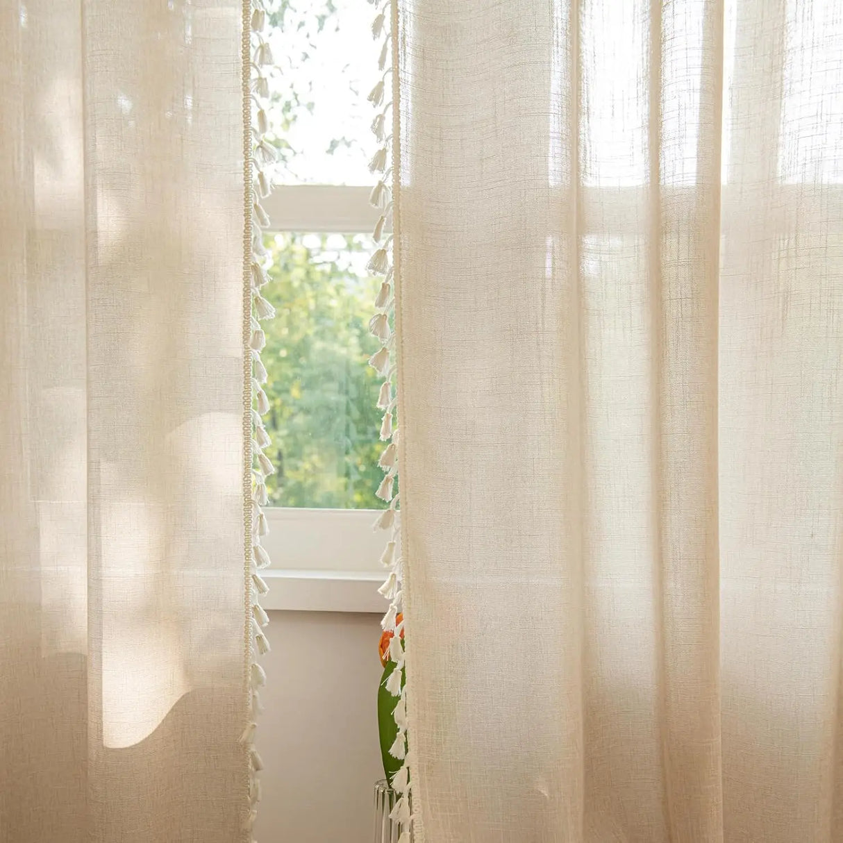 Beige sheer panels hanging in sunlit farmhouse living room 