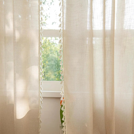 Beige sheer panels hanging in sunlit farmhouse living room 