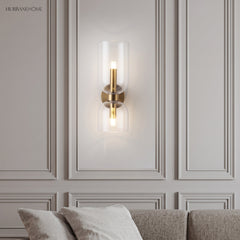 Glass wall sconce on a moulded wall above a sofa in a living room