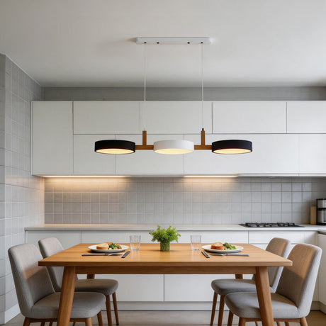 Black and white drum shades lighting a dining table in a white tiled kitchen