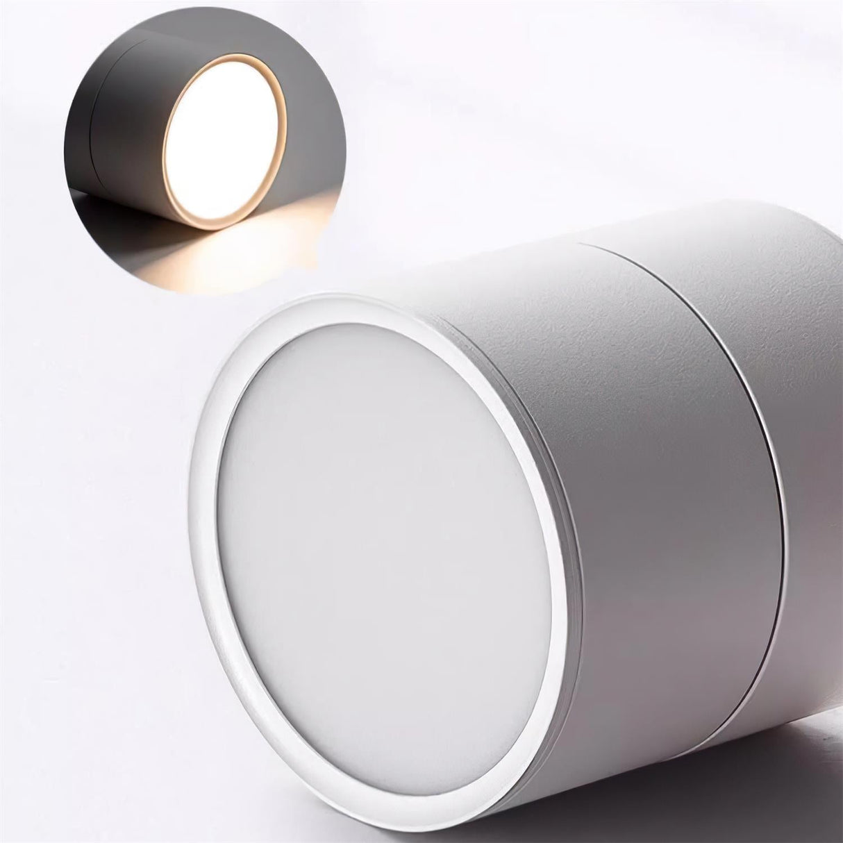 Detail of a black spot light head beside a white one showing the lit lens