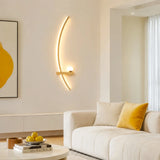 Black curved linear wall light lit warm on a textured plaster wall