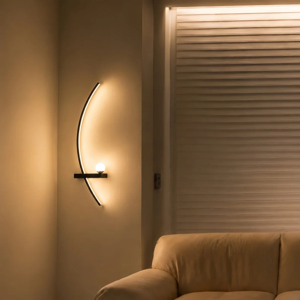 Black arc wall sconce viewed from an angle with a soft upward glow