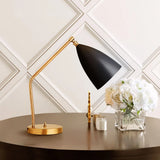 Black shade brass table lamp on a dark round table