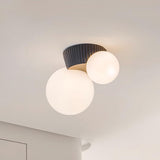 Close view of the black fluted canopy holding the two lit opal globes