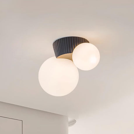 Close view of the black fluted canopy holding the two lit opal globes