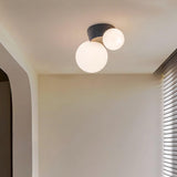 Black canopy globe ceiling light lit in the corner of a plain white hallway