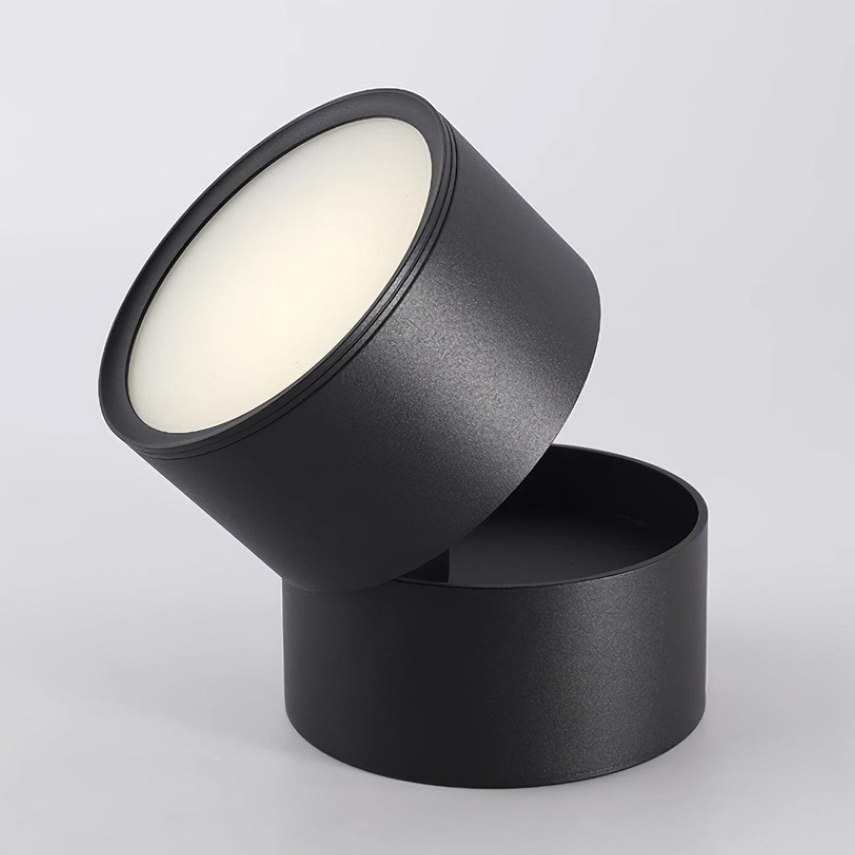 Close product view of the black spot light head tilted back on its round base