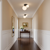 Black canopy globe lights above a panelled hallway with a framed landscape