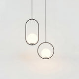 Black and gold oval frame pendant lights with opal glass globes hanging together