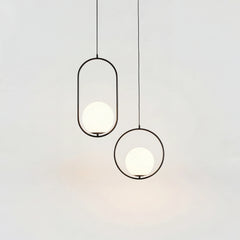 Black and gold oval frame pendant lights with opal glass globes hanging together