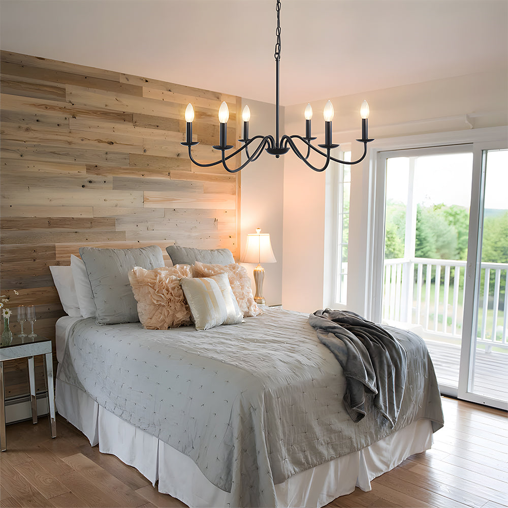 Black candle chandelier above a bed with a reclaimed timber feature wall
