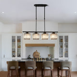 Black kitchen island pendant light above a breakfast bar with four rattan stools