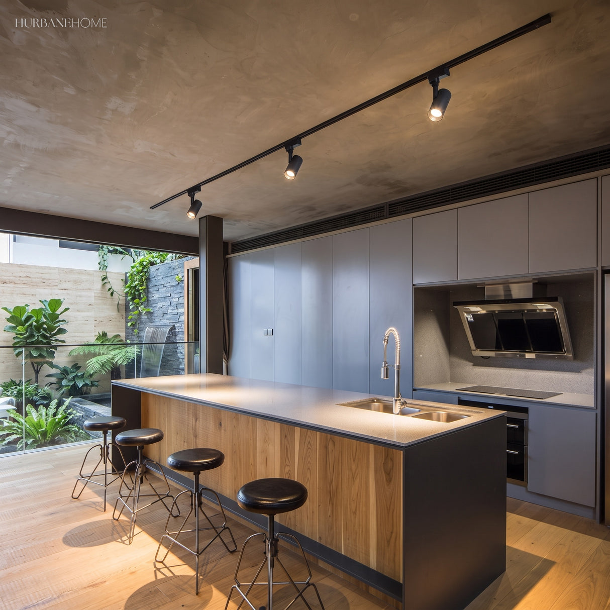 Black track spotlights over a timber kitchen island and bar stools