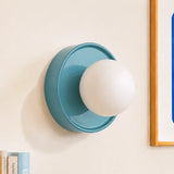 Blue ceramic orb wall sconce shown straight on against a plain background