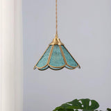 Blue glass pendant hanging beside a pale curtain with the frame clearly visible