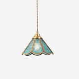 Studio view of the blue panelled glass shade in its scalloped brass frame