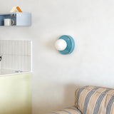 Blue orb wall sconce photographed against a soft neutral studio backdrop