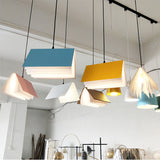 Book shaped pendant lights lit and grouped under a ceiling track