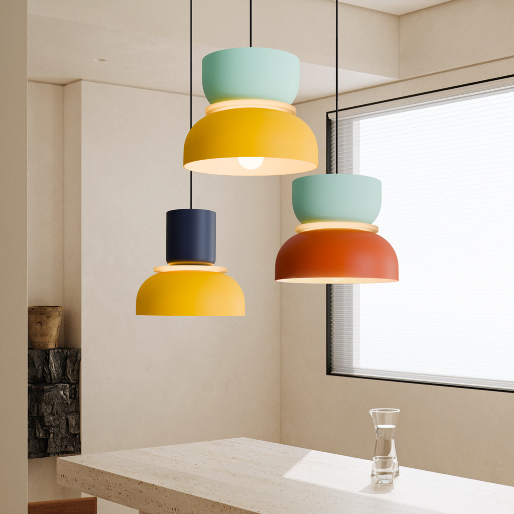 Three colorful pendant lights hanging in a soft beige room