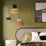 Four colorful pendant lights in an olive-green bedroom