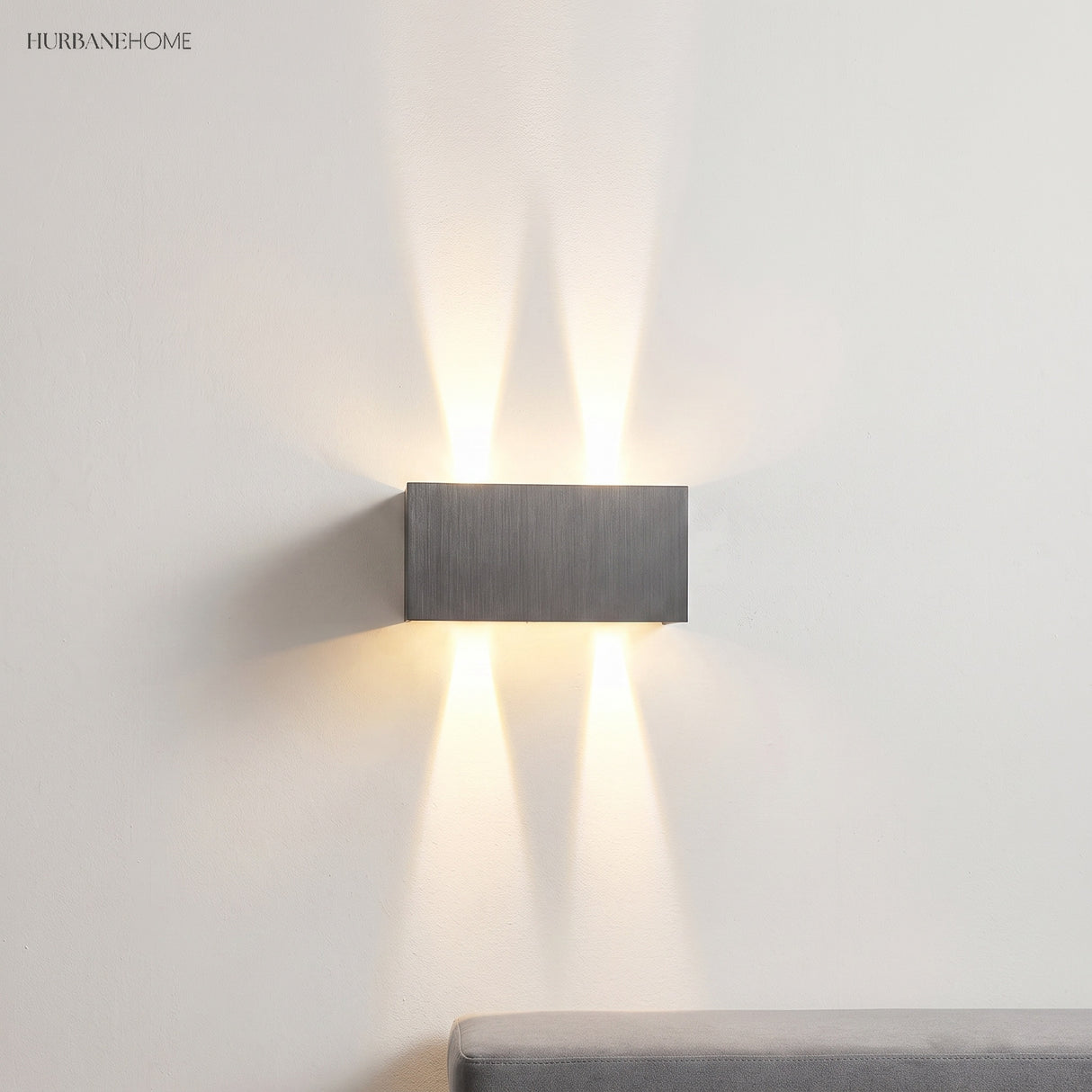 Two grey wall sconces lighting a marble staircase up and down