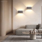 White wall sconce accenting a living room wall with warm glow