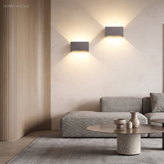 White wall sconce accenting a living room wall with warm glow