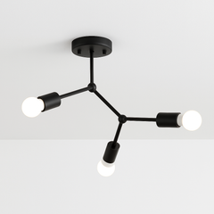 Black three light branch fixture mounted on a white ceiling