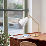 Brass table lamp with matte cone shade angled