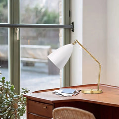 Brass table lamp with matte cone shade angled