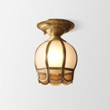 Tall caged glass panel shade in a brass frame on plain white
