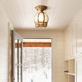 Caged glass ceiling light lit in a white boarded corridor