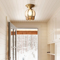 Caged glass ceiling light lit in a white boarded corridor