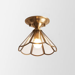 Flared glass panel shade in a brass frame shown on plain white