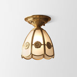 Rosette trimmed glass panel shade in a brass frame on plain white