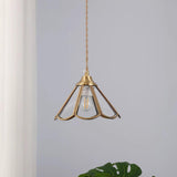 Open brass framed pendant unlit beside a curtain with the bulb showing