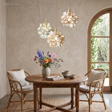 Cluster of brass and glass petal pendant lights above a round dining table