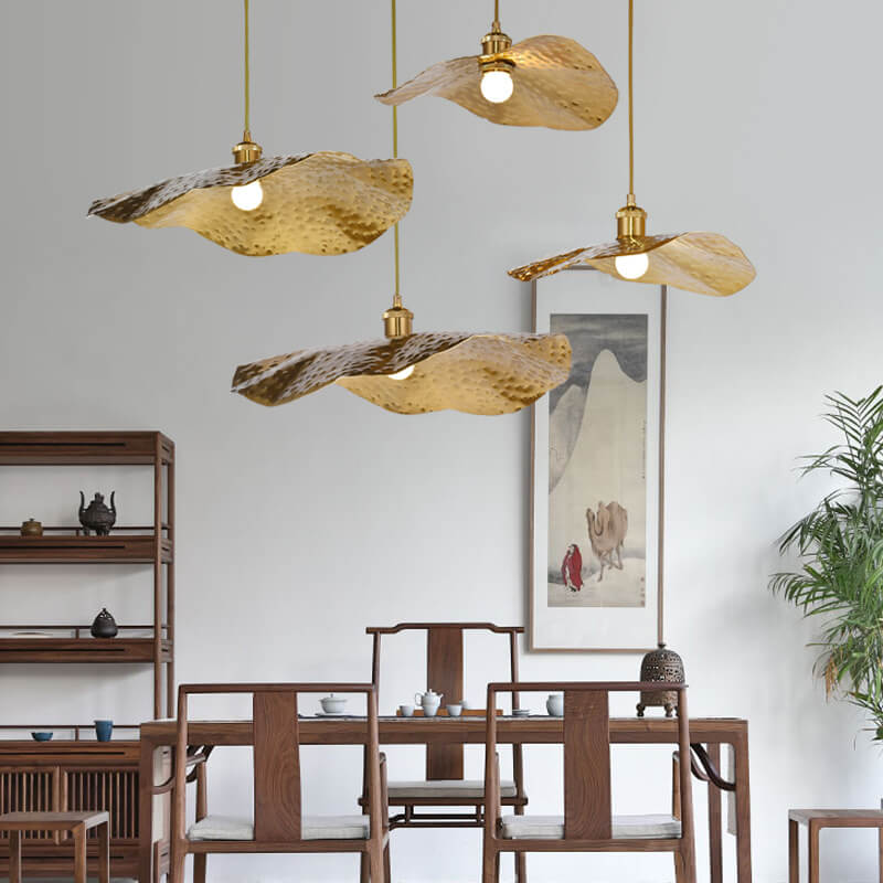 Cluster of brass lotus leaf pendant lights over a wooden dining table