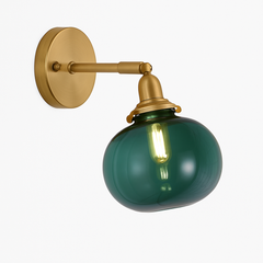 Brass wall sconce holding a smooth dark green glass shade
