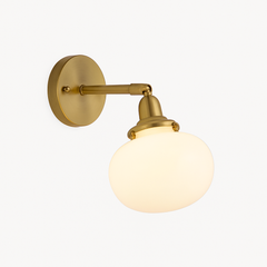 Brass wall sconce holding a smooth white opal glass shade