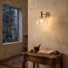 Two glass dome sconces flanking an arched mirror above a vanity
