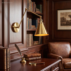 Brass swing arm sconce lit above a leather chair and old books